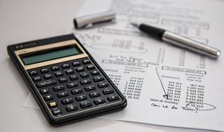Calculatrice et stylo posés sur des documents chiffrés