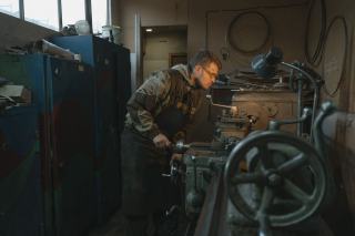 Tourneur au travail sur un tour conventionnel dans un atelier de mécanique
