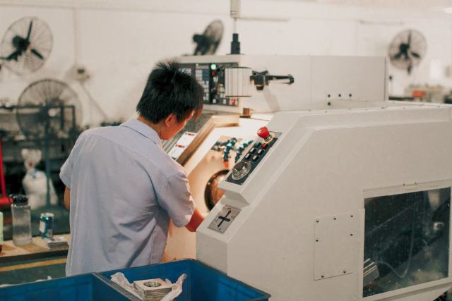 Maintenance, automatisme, usinage : les métiers d'atelier Opérateur aux commandes d'une machine d'usinage dans un atelier de production