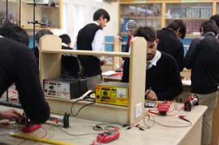 Élèves travaillant sur des montages électroniques aux postes d'un atelier de formation